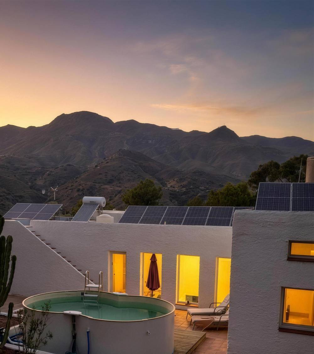 Solar panels and lit windows at dusk